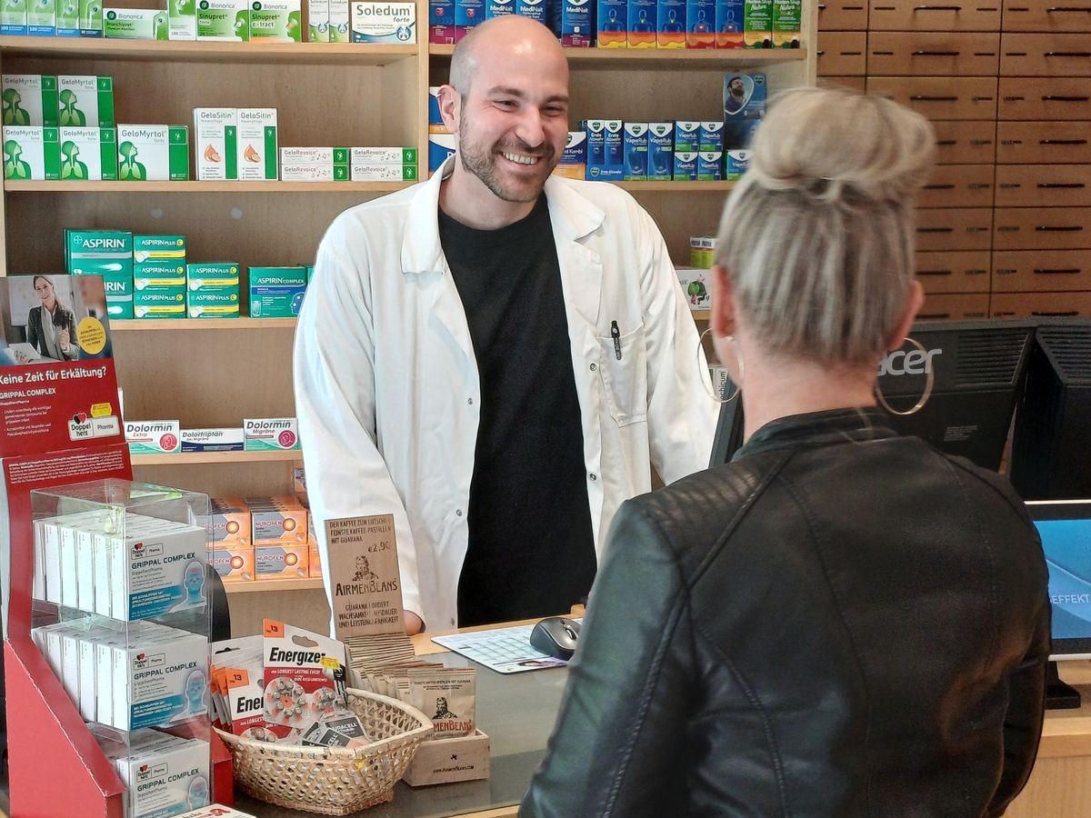 Apotheker berät einen Kunden zur richtigen Antibiotika-Einnahme in der Apotheke in der Galenusstraße in Berlin